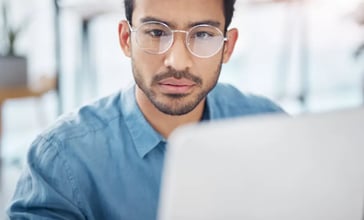 Mann mit Brille vor Laptop